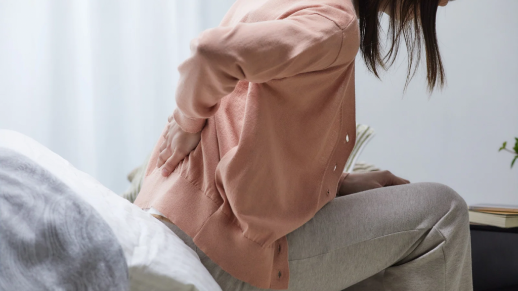 産後に腰痛や骨盤の痛みを感じている女性のイメージ