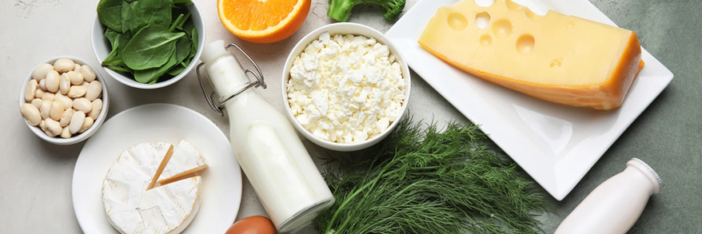 カルシウム・マグネシウムが豊富な食材を並べた写真｜乳製品・チーズ・豆類・ほうれん草・オレンジ